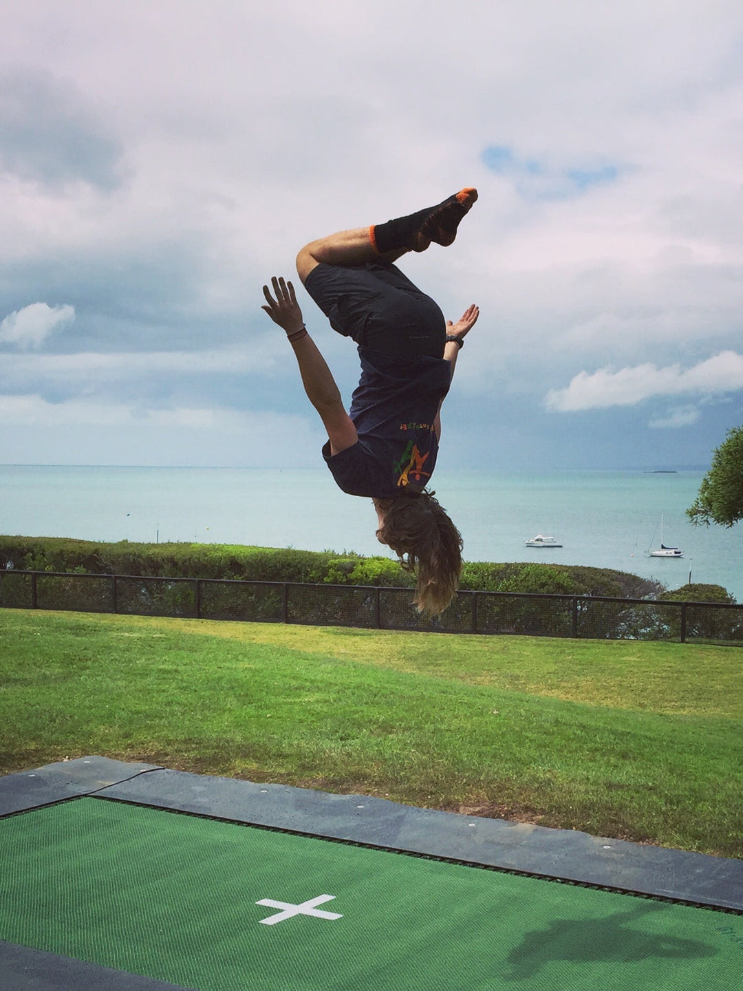 boy bouncing on trampoline near the beach