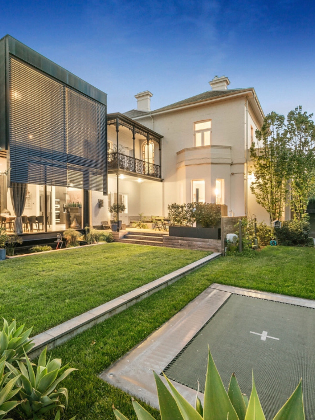 Modern house with a well-maintained garden and outdoor area including a in ground trampoline
